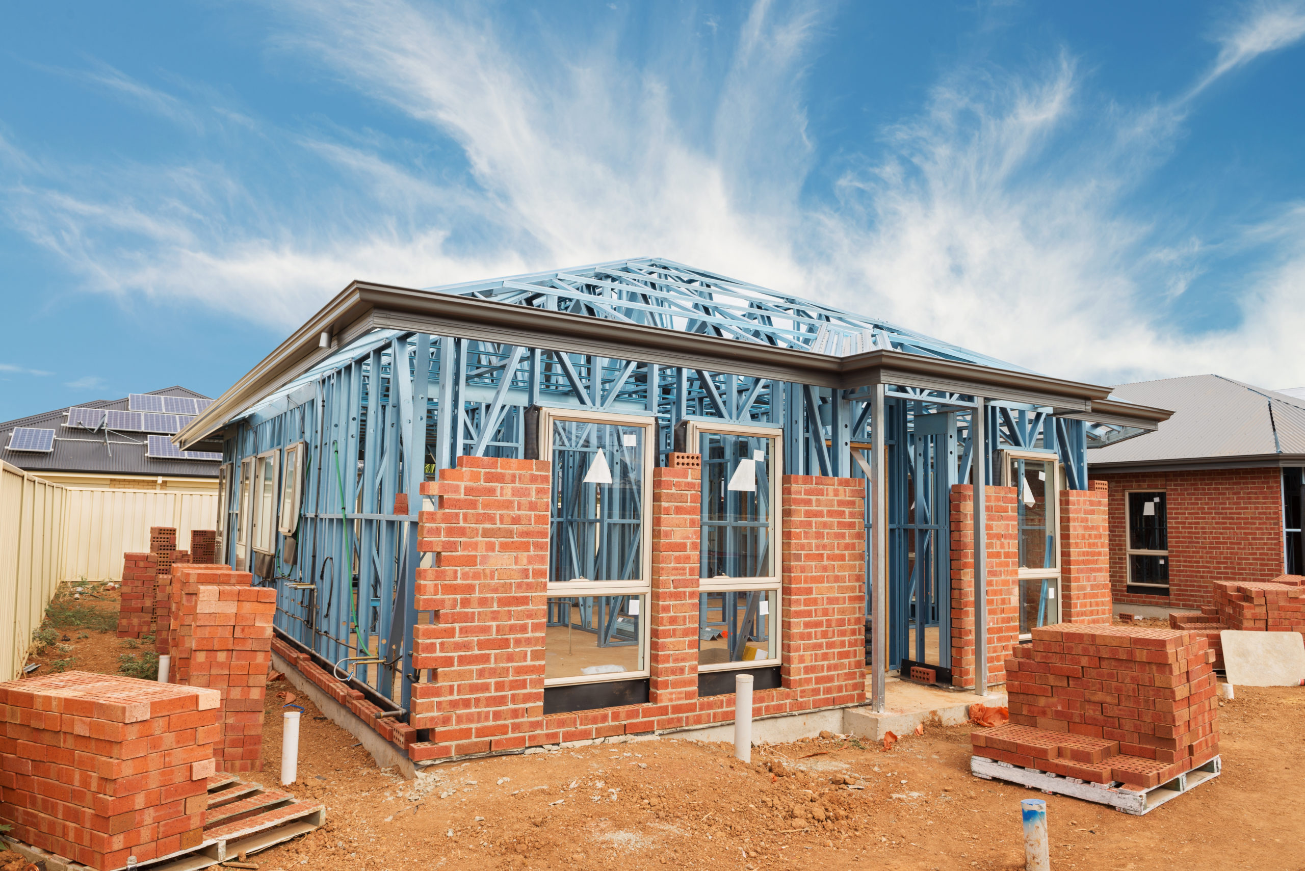 New,Residential,Construction,Brick,Home,With,Metal,Framing,Against,A